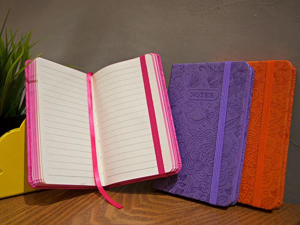Cuaderno tipo Moleskine, páginas con bordes de colores, cierre con banda elástica, marcados de página,  96 páginas en blanco